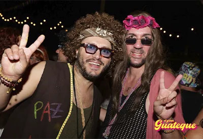 Dos chicos saludando ante la c�mara vestidos de los 70 en El Gran Guateque