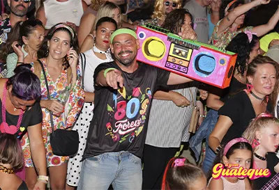 Chico vestido de la �poca de los 80`s con radio en el hombro entre el p�blico