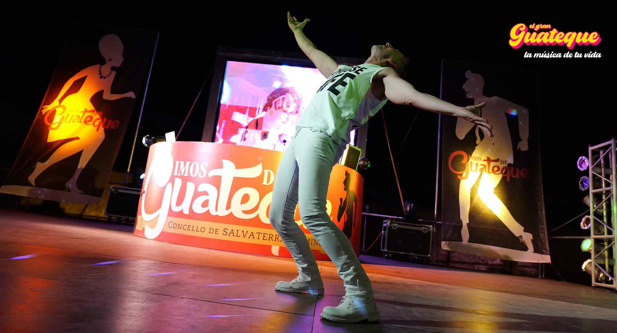 Edi FM con los brazos abiertos, inclinado, bailando, camiseta 'Chose Life', todo de blanco, representando la d�cada de los 70 en El Gran Guateque