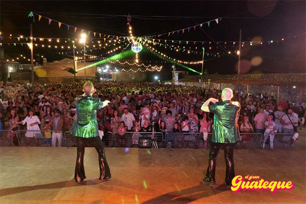 X.avi PetardPop y Edi FM de espaldas con chaquetas verdes y pantalones negros de brillantina, bailando en El Gran Guateque; p�blico abarrotando el recinto con la gran bola de espejos y el paraguas decorativo iluminado con banderas y bombillas