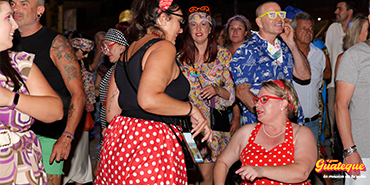 Grupo de personas bailando con ropa retro de los 60s a 80s en El Gran Guateque